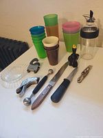 All items laid out showing cups, utensils, knives, butter dish, dressing bottle