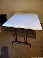 Top view of plywood table on black metal folding legs