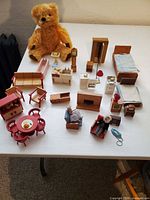 Overall view of teddy bear and full set of miniature furniture on table