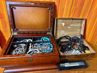Overall view of two open wooden boxes filled with jewelry