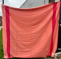 Full view of pink Hudson's Bay blanket hanging, showing stripes and size
