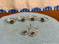 Full view of four rings and earrings