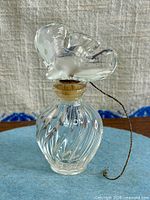 Front view of ribbed glass bottle with frosted dove stopper and hanging cord