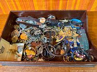 Overview of wooden tray showing variety of jewelry pieces