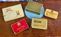 Group shot of all five tins on wooden surface