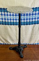 Full view of granite-top pedestal side table