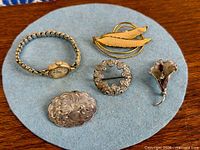 All five jewelry items displayed on blue felt
