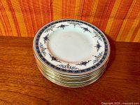 Stack of eight Minton Grasmere side plates showing cobalt blue and gold border
