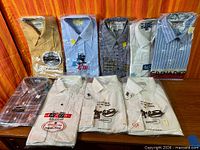 All eight sealed vintage shirts displayed front on table