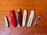 All six pocket knives laid out showing handles