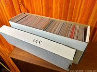 Full long box filled with comics with additional empty long box lid beside it