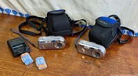 Full lot showing two cameras, two cases, charger and batteries