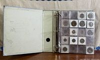 Open binder showing plastic page of coins in flips