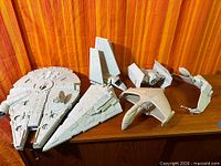 Group shot of five assembled grey plastic spacecraft models on shelf