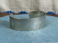 Front view of hammered silver cuff bracelet showing texture and width