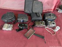 Full lot showing all cameras, camcorder, magnifier, film roll and cases