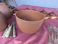 Brown textured plastic bowls, steak knives, ceramic crocks in background