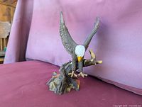 Side view of largest resin bald eagle figurine landing on branch