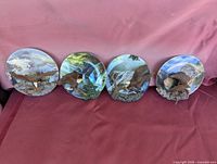 Front view of four eagle relief plates laid out side by side