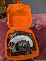 Circular saw in open orange case