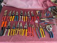 Full layout of tin snips, pliers, screwdrivers and other tools on table
