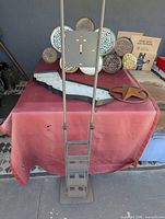 Vacuum stand front view with three metal wall art pieces behind on table