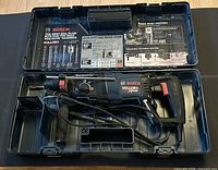 Rotary hammer, handle, depth gauge inside open Bosch case