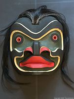 Front view of carved mask showing colours and hair