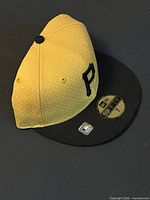 Top angled view of yellow crown and black visor showing front logo and size sticker