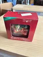 Front view of ornament inside original red Forget Me Not box