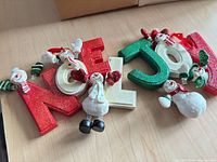 NOEL and JOY glitter letters with attached snowmen displayed on tabletop