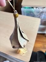 Full view showing ornament shape, cord loop, tassel
