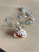 Front view of seashell ornament showing shell base and wire branches with gems