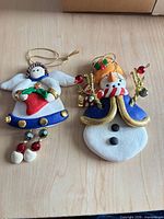 Front view of angel and snowman polymer clay ornaments