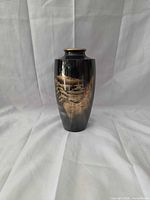 Front view of black vase with gold pagoda landscape