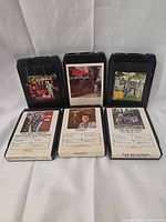 Front view of all six 8-tracks standing and lying flat