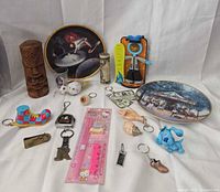 Group layout showing plates, tiki, figures, keychains, shot glass, stationery