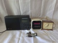 Front view of all four devices: CCRadio/DX, Sony clock radio, GE analog clock, silver FM scan radio