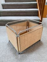 Angled view of crate showing jute panels and chrome frame