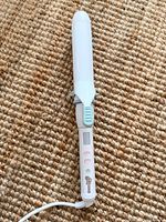 Full view of curling iron showing barrel, clamp, handle and cord