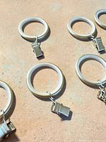 Close view of several rings showing gold finish and attached clips