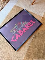 Full framed Smilin' Buddha Cabaret print lying on carpet