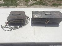 Battery charger and closed metal toolbox on tabletop