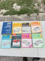 Eight automotive repair manuals laid out in two rows, showing front covers and titles
