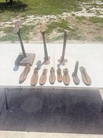 Full lot: three upright stands and eight lasts on table outdoors