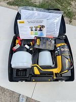 Complete kit in open carrying case showing sprayer, two cups, paperwork