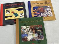 Front covers of three hardcover books Griffin & Sabine, Sabine's Notebook, The Golden Mean