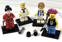 All four minifigures shown with accessories on stands
