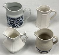 Group of four pitchers showing shapes and colors