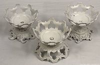 Three white painted cast iron stands front view